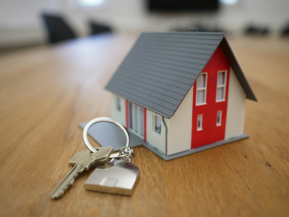 Red toy house with a house key chain next to it